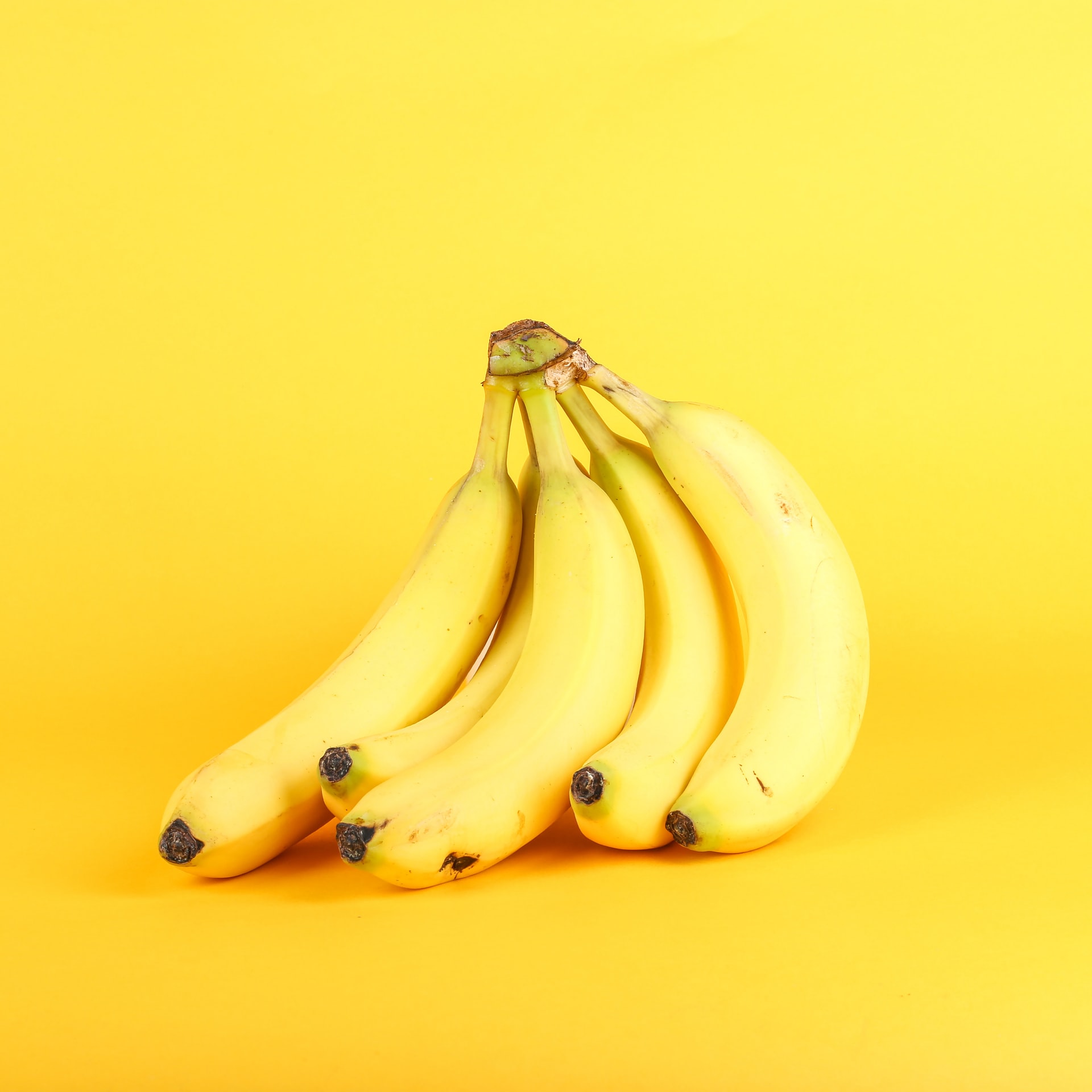 A bunch of bananas on a yellow background