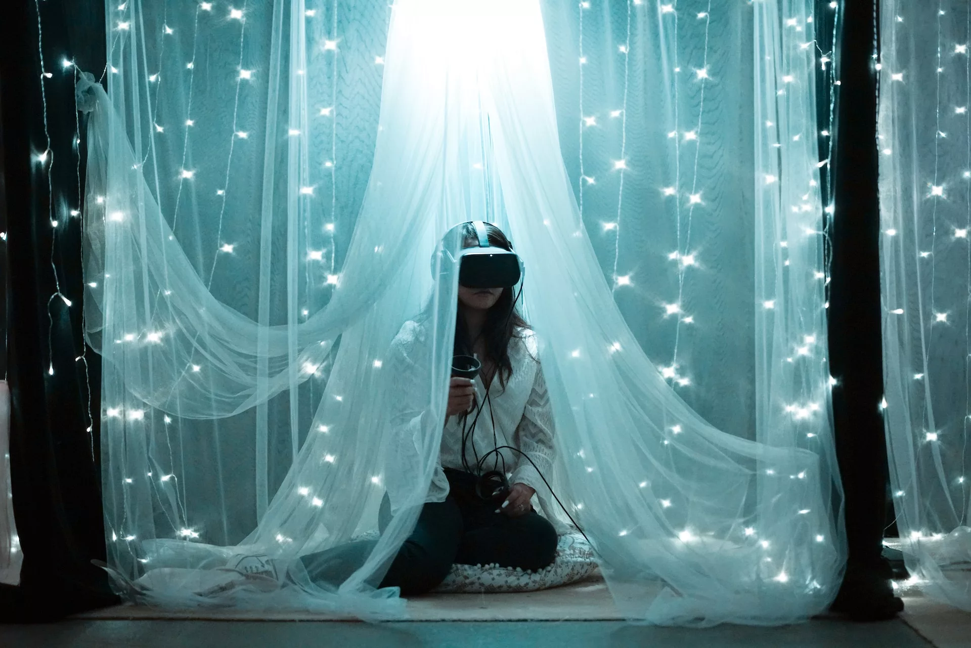 woman with a virtual reality headset, within an enclosed, lighted area